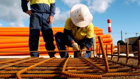 Two construction workers laying rebar